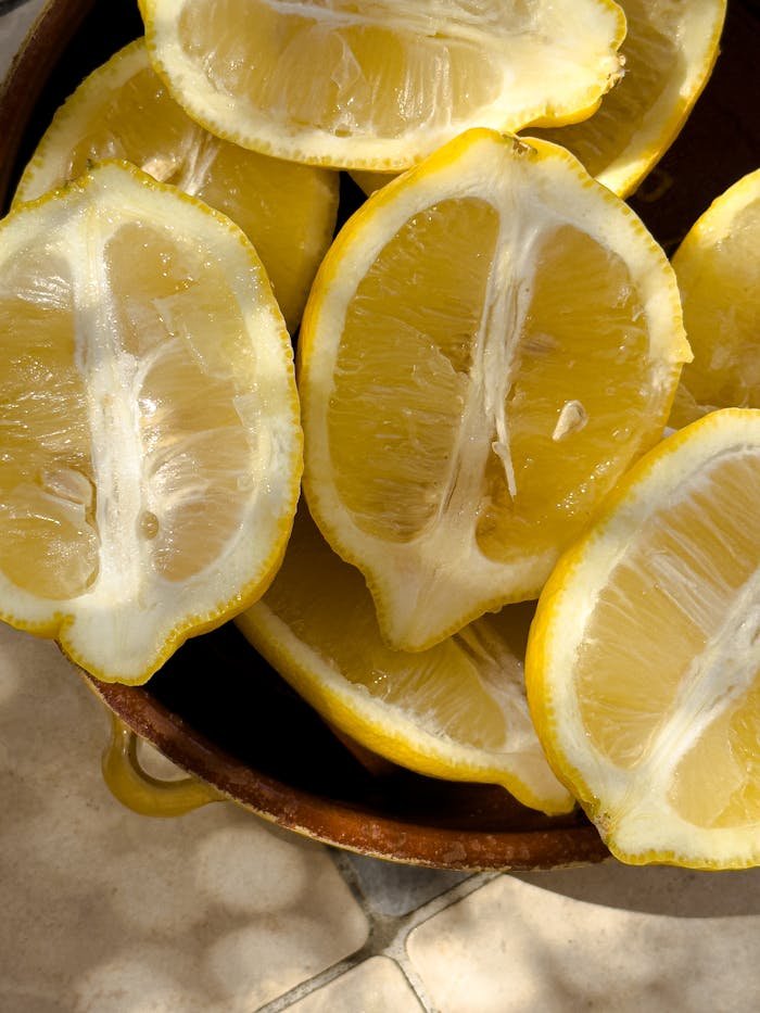 Close-up of fresh lemon slices in a basket with warm sunlight, perfect for food and lifestyle themes.